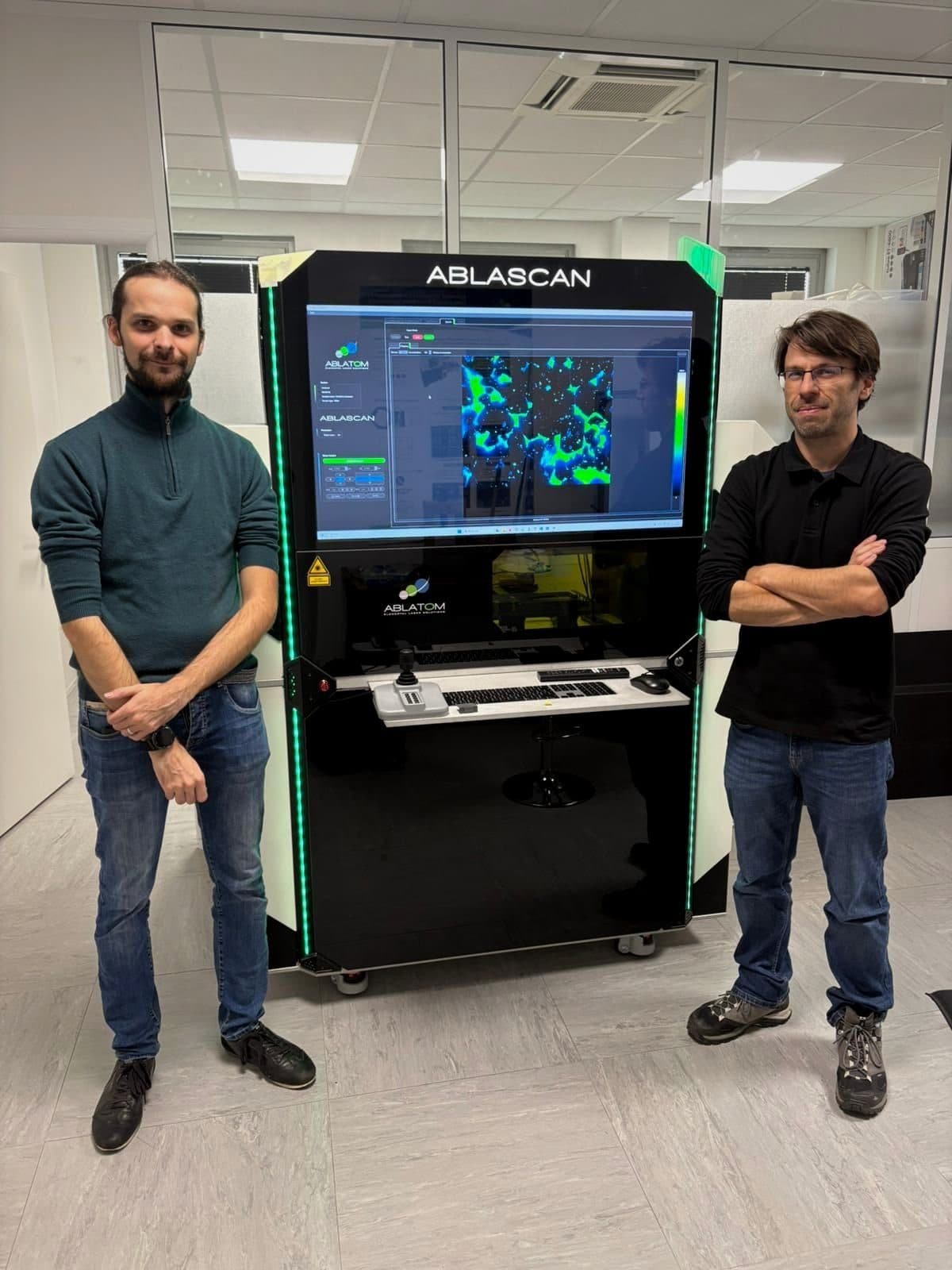Two researchers next to the Ablascan instrument at Ablatom